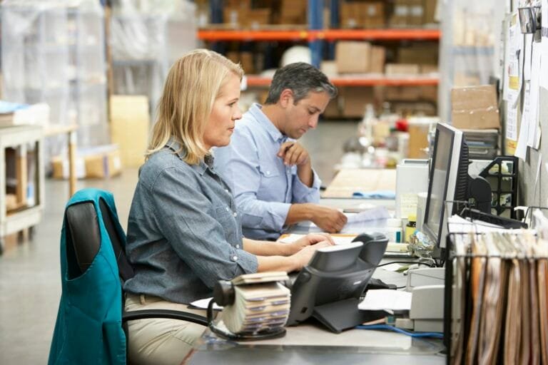 Business Colleagues Working At Desk In Warehouse