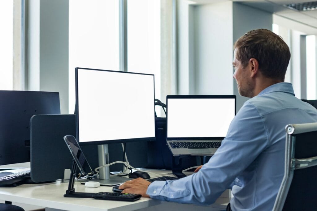 From behind male manager businessman in blue shirt works in corporate office