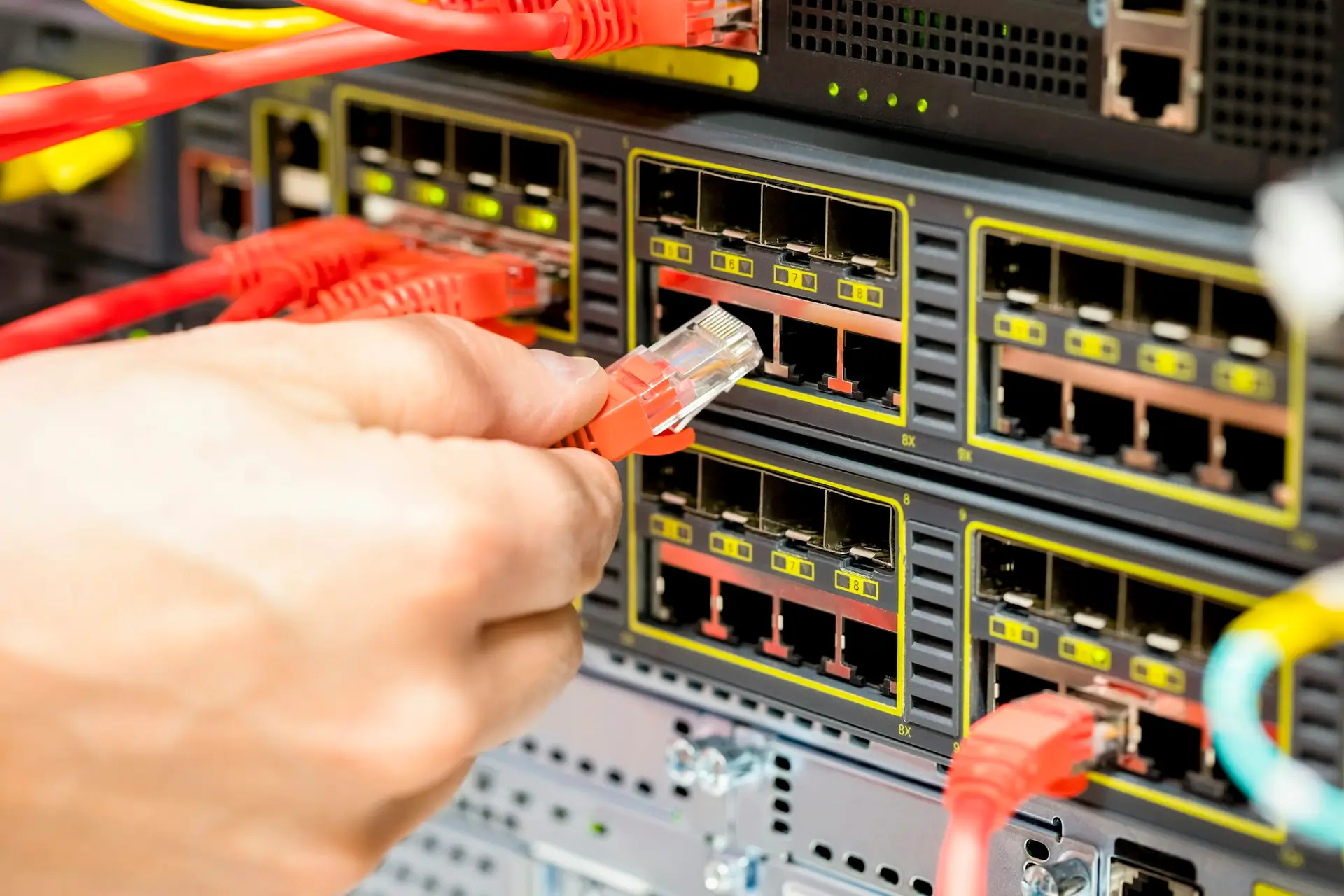 Hand Plugging Fiber Cable Into Switch In Datacenter